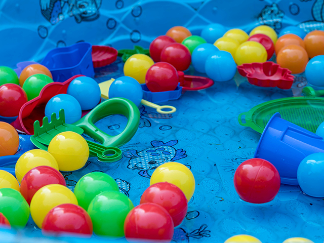 Children's plastic toys float in a shallow kiddie pool