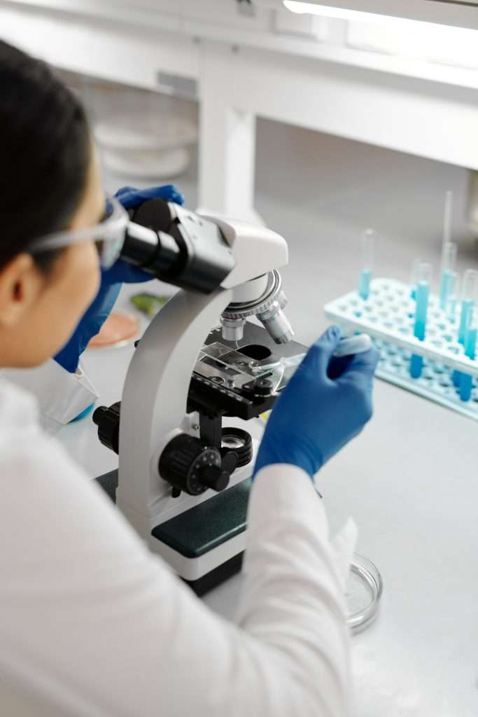 Lab tech using a microscope